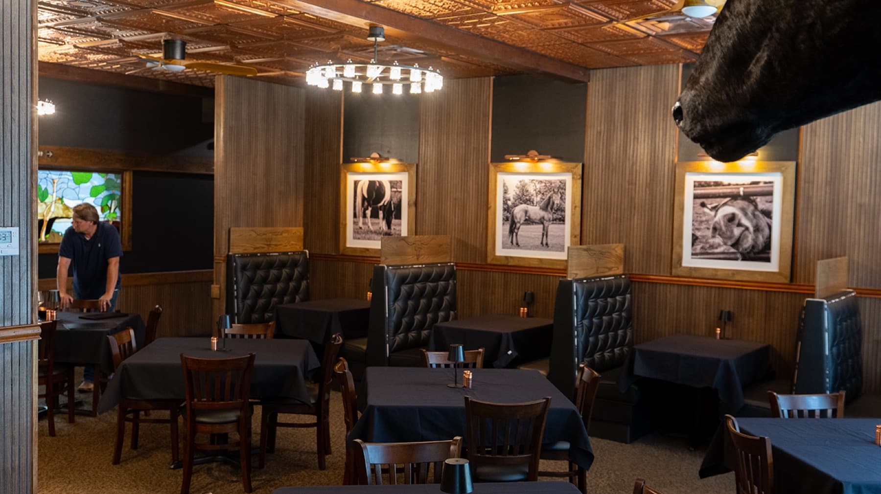 The dining room with tufted booths and copper ceiling
